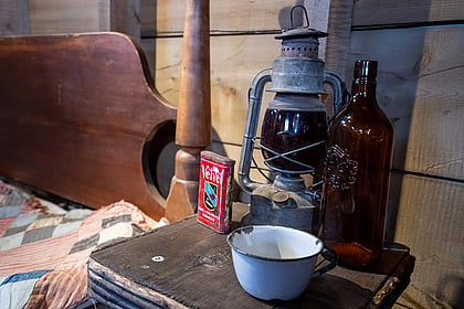 A western frontier lantern sitting next to a bed