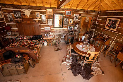 An authentic cabin with pelts and bed and table
