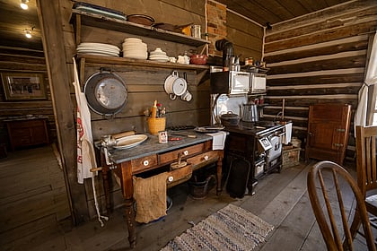 An old frontier kitchen with pots, pans, and stove top